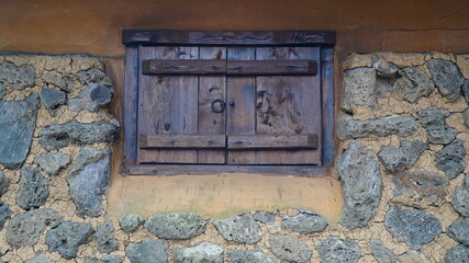 Stone wall and wooden window of Jeju traditional house