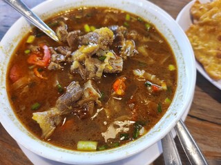 A bowl of steaming tongseng kambing, an Indonesian spicy goat soup.