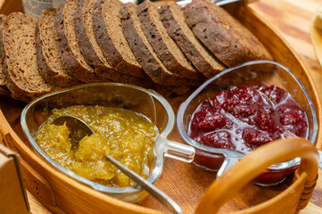 Rustic rye bread with heart-shaped bowls of jam and marmalade