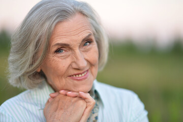 Portrait of a beautiful elderly woman in the park