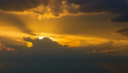 Naklejka premium 구름이 걷히며 어두운 하늘 사이로 환하게 비치는 황금빛 태양
