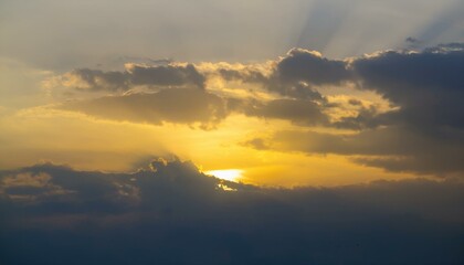 Fototapeta premium 구름이 걷히며 어두운 하늘 사이로 환하게 비치는 황금빛 태양