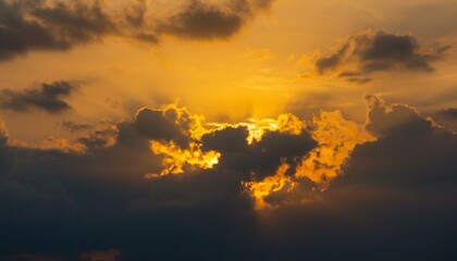 Naklejka premium 구름이 걷히며 어두운 하늘 사이로 환하게 비치는 황금빛 태양