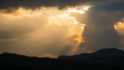 구름이 걷히며 어두운 하늘 사이로 환하게 비치는 황금빛 태양