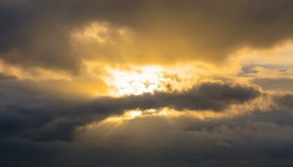 구름이 걷히며 어두운 하늘 사이로 환하게 비치는 황금빛 태양
