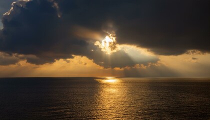 구름이 걷히며 어두운 하늘 사이로 환하게 비치는 황금빛 태양