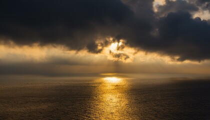 구름이 걷히며 어두운 하늘 사이로 환하게 비치는 황금빛 태양