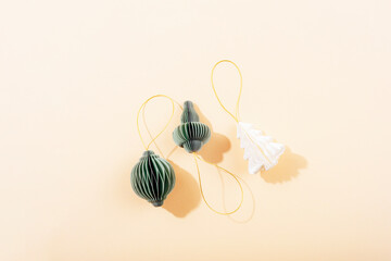 Paper Christmas ornaments on beige background with shadows. Flat lay, copy space