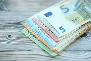 Big amount of different denominations of euro money bills on wooden background