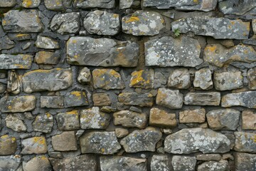 Fototapeta premium Photo of Old grey and brown stone wall. Background texture for backdrops or mapping