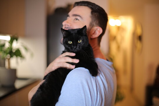 Man holding a black british short hair cat  - Powered by Adobe