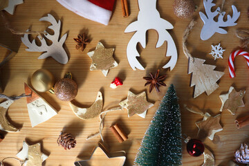 Various Christmas decorations in neutral colors on wooden background. Flat lay.