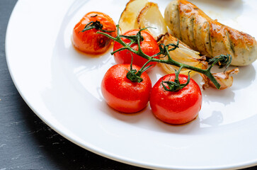 .Juicy Fried fatty sausages with cherry tomatoes for dinner. Home-made food.
