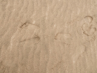 Fresh human footprints on dry sand. Go ahead. Top view. Blank space for text, quotes or sayings.