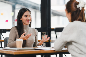 Two women having friendly conversation at cafe table