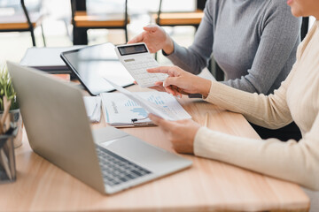 Two women discussing financial documents with calculator