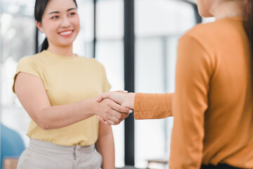 Fototapeta premium Two women shaking hands in friendly business meeting