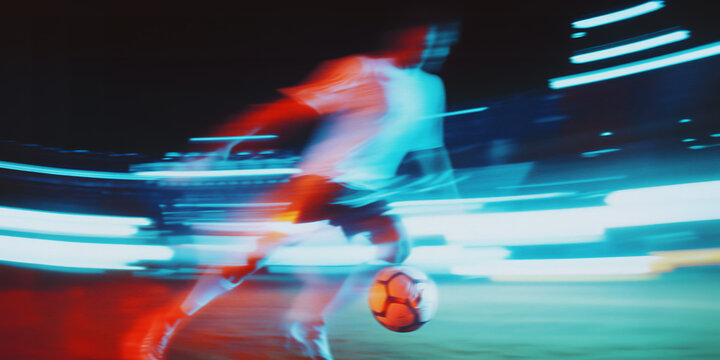 Soccer player in dynamic motion striking the ball during a night match, illuminated by glowing red and blue light trails, showcasing speed, precision, intense athletic energy, grain and motion blur - Powered by Adobe