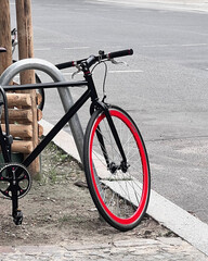 Fototapeta premium Modern Black Bicycle with Red Rim Parked on Street in Berlin, Germany