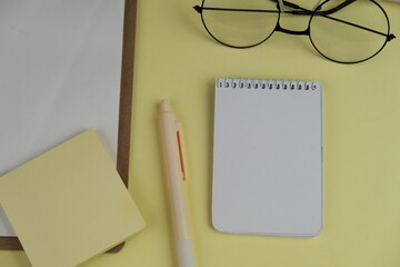 Home office workspace mockup with laptop, clipboard, palm leaf, notebook and accessories. Flat lay, top view