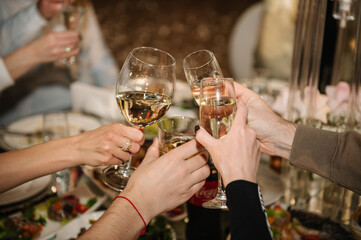 Cheers. People celebrate and raise glasses of wine for toast. Group of man and woman cheering with champagne.