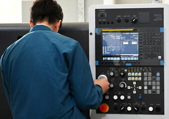 Factory workers using CNC lathe machine