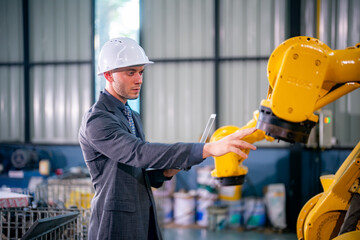 Engineer Inspecting Robotic Arm in a Modern Manufacturing Facility Focused on Automation