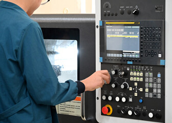 Factory workers using CNC lathe machine