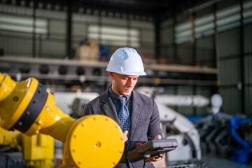 Aerial view of an industrial workspace with a worker inspecting robotic machinery