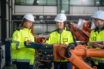 Team of engineers collaborate on automation project in modern manufacturing facility