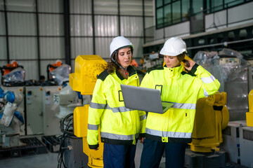 Women Engineers Collaborate on Robotics Project in Factory Setting