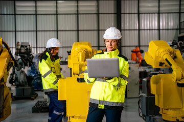 Modern factory setting showcases workers using technology to manage robotic systems efficiently