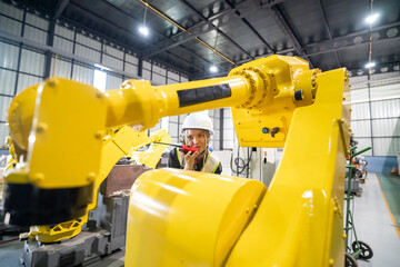 Industrial Robot in Operation With Technician Observing in a Modern Manufacturing Facility