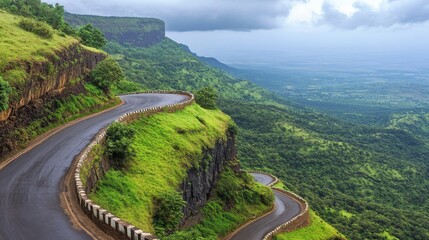 Fototapeta premium Scenic Winding Road Through Lush Green Mountains Under Cloudy Sky