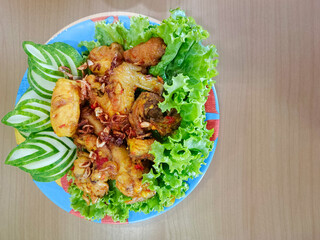 Balinese Ayam Betutu is an authentic Indonesian food from Bali. This food consisting of spicy roasted chicken, sambel matah, steamed rice and stir-fried vegetables.