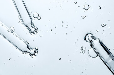 Three pipettes and a serum texture for skin with bubbles. Liquid body care product. Close-up.