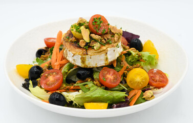 Ensalada con queso de cabra, aceitunas y tomates sobre fondo blanco