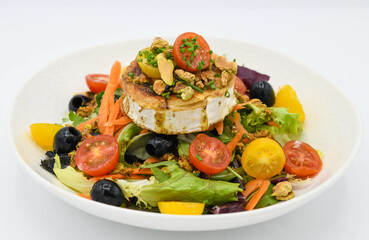 Ensalada con queso de cabra, aceitunas y tomates sobre fondo blanco