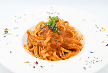 Fideos a la boloñesa con salsa de tomate en un plato blanco