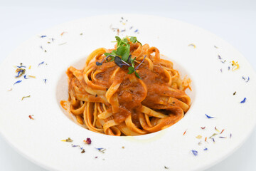Fideos a la boloñesa con salsa de tomate en un plato blanco