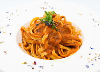 Fideos a la boloñesa con salsa de tomate en un plato blanco