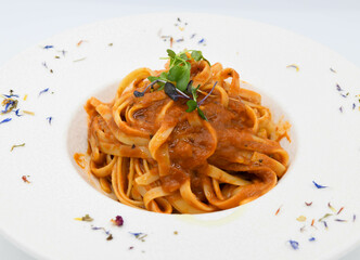 Fideos a la boloñesa con salsa de tomate en un plato blanco