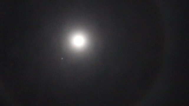 Full Moon Halo Surrounded by Misty Night Sky Atmospheric Phenomenon with Glowing Light Circle Effect Captured in Dark Cloudy Environment Natural Optical Illusion in Astronomy and Weather Photography  