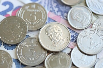 Ukraine money coins lying on mixed hryvnia banknotes. Finance background concept.