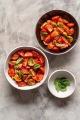 Bowls of  tomato salad with basil leaves and oregano decoration.