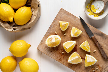 Group of lemons on light wooden table.