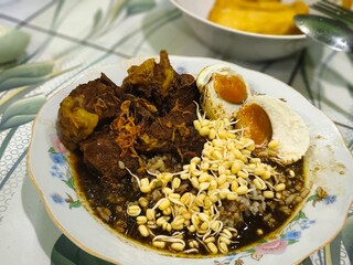 A bowl of Rawon, a rich and flavorful Indonesian beef stew.