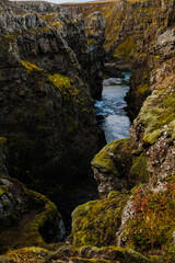 Obraz premium River surrounded by mossy Icelandic cliffs