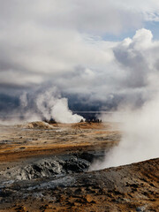 Steaming geothermal landscape under dramatic cloudy skies in Iceland