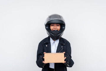 Young female delivery worker holding small package in helmet and uniform